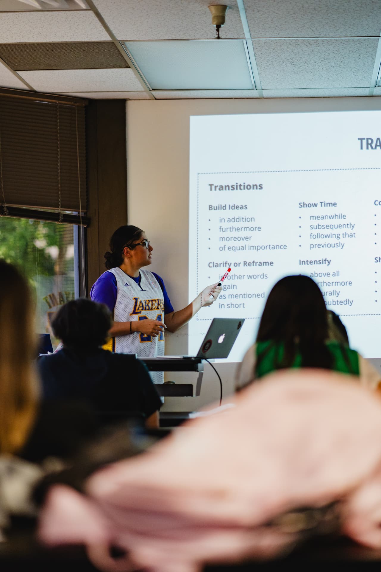 A USLING instructor teaching a lesson on English transitions to a class of students